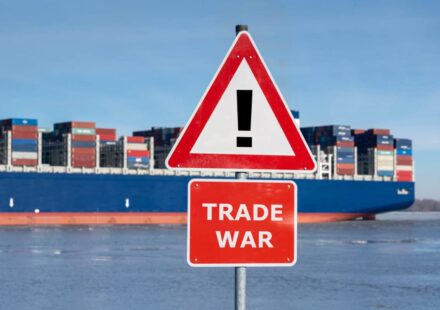 Warning sign with the text "Trade war" in front of container ship