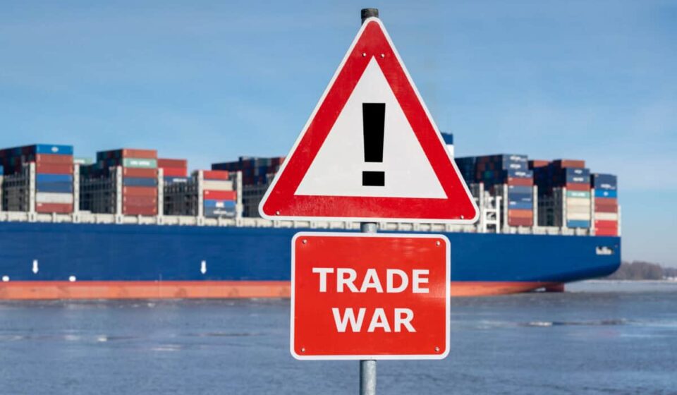 Warning sign with the text "Trade war" in front of container ship
