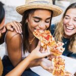 three friends eat pizza