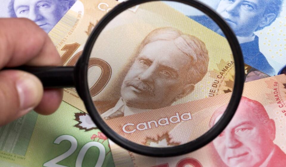 Canadian dollars in a magnifying glass