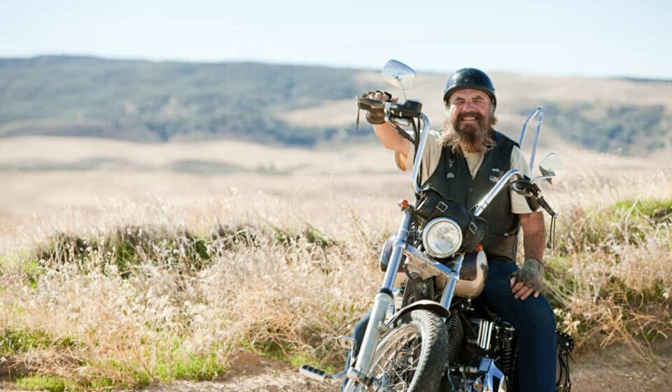 motorcycle rider smiles on bike