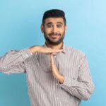man makes the timeout gesture with his hands