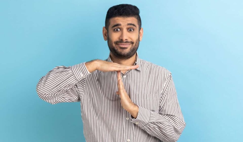 man makes the timeout gesture with his hands